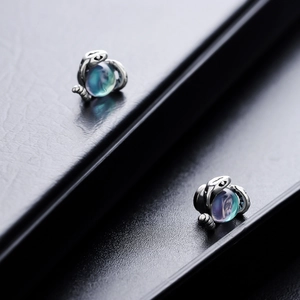 Boucles d'oreilles serpent œil de Méduse avec gemme bleue sur fond en cuir noir
