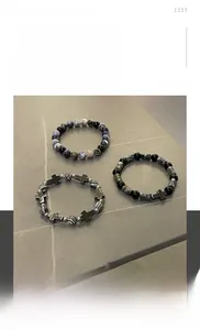 Detailed view of hip hop style beaded bracelet set with metallic cross pendants
