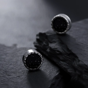 Magnetic star-studded black stud earrings on dark rock, minimalist unisex silver style