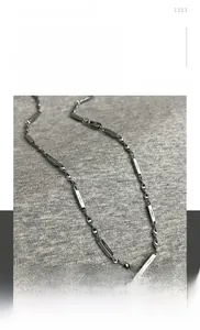Detailed close-up of Mobius titanium steel chain with rectangular plate and star accents