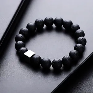 Minimalist black volcanic stone bracelet with a silver geometric cube bead centerpiece