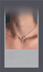 Detailed close-up of hip-hop silver angel wing necklace with sparkling stone accents