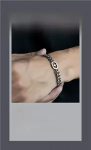 Close-up of titanium steel Cuban link bracelet with a North Star oval charm engraving