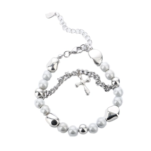 Polished silver beaded bracelet with cross pendant and pearls on white background