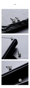 Detailed view of silver maple leaf pattern earrings on a textured black stone surface