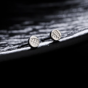 Minimalist silver maple leaf earrings with textured vein design on polished metal surface