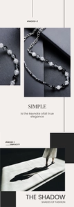 Macro shot of minimalist long bead necklace featuring black beads and marble texture detail