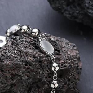 Sleek cat eye stone beaded necklace with polished silver beads on volcanic rock