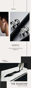 Detail view of silver and black minimalist C-shaped ear cuffs with smooth metal finish