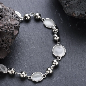 Elegant silver bracelet with moonstone beads on dark natural rock background