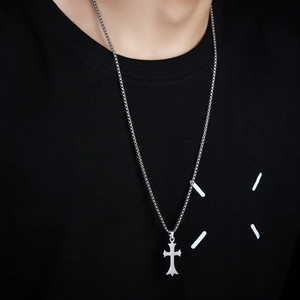 Minimalist silver irregular cross pendant necklace on box chain worn over a black shirt