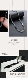 Gros plan d'un collier en argent avec des maillons géométriques éclair au style industriel
