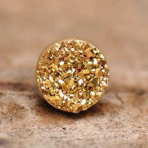 Macro detail of golden druzy crystal magnetic clip-on earring with sparkling texture