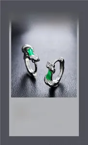 Detail of silver bamboo earrings with emerald green inlay and hammered metal texture
