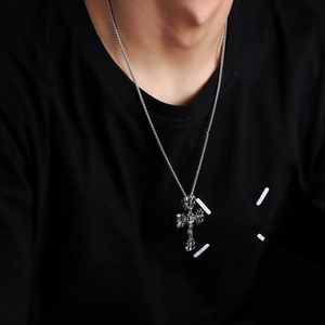 Gothic reliëf kruis hanger ketting in retro zilver gedragen op een zwart t-shirt