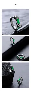 Detail of silver bamboo joint hoop earrings with green enamel on volcanic stone background
