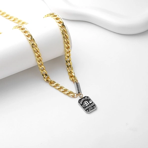 Collier chaîne gourmette dorée avec doubles pendentifs gravés Good Luck sur socle blanc