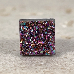 Macro shot of square rainbow druzy magnetic earring with shimmering crystal textures