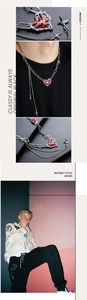 Détail d'un collier punk multicouche avec pendentif cœur rouge et breloques en croix