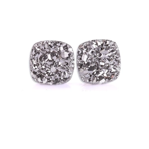 Macro detail of square magnetic ear clips with raw silver crystal cluster texture finish