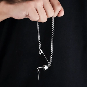 Collier punk argenté avec breloques trombone, cœur et rivet sur fond noir