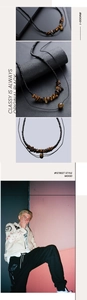 Close-up of street style necklace with black beads and natural tiger eye stones on a model