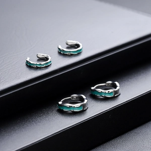 Moderni orecchini in argento con trama in smalto verde acqua su espositore nero