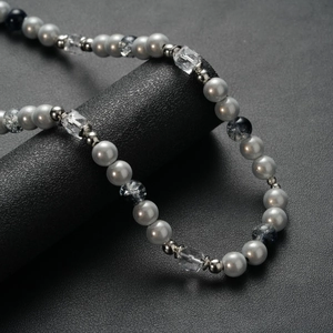 Collier en acier titane pour homme avec perles grises et bleues sur support noir