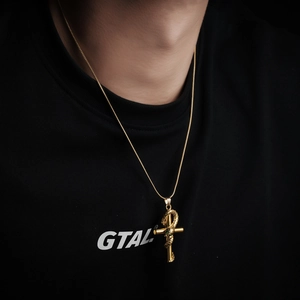 Golden snake cross pendant necklace with green gemstone on sleek snake chain