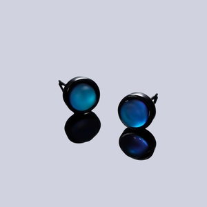 Minimalist round stud earrings with blue cat eye stones and black metal circular frames
