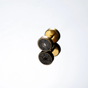 Gold round stud earrings with black radial pattern and crystal inlay on mirror surface