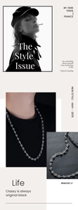 Close-up of silver knot necklace with barbed wire design on black rock background