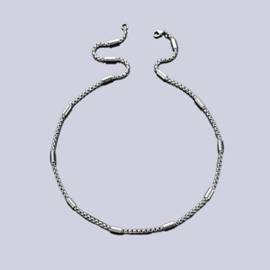 Silver stainless steel box chain necklace with cylindrical beads on blue-grey background