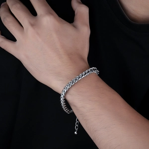 Bracciale da uomo in acciaio al titanio con maglia intrecciata argento indossato al polso