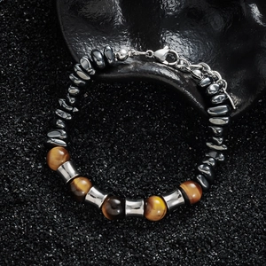 Tiger eye and hematite beaded bracelet with polished silver spacers on dark stone