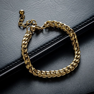 Macro detail of gold Cuban link chain bracelet with adjustable ball charm on black leather
