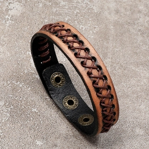 Detail view of woven brown leather bracelet with triple metal snap button fasteners