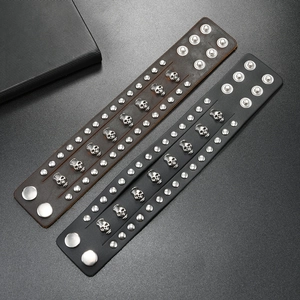 Close-up of punk leather bracelets featuring silver skull studs and metal rivets detail