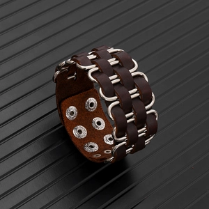 Detail of wide brown leather punk bracelet with silver metal rings and snap buttons