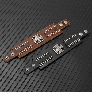 Detail of vintage punk leather bracelets with cross emblem and hand-stitched textures