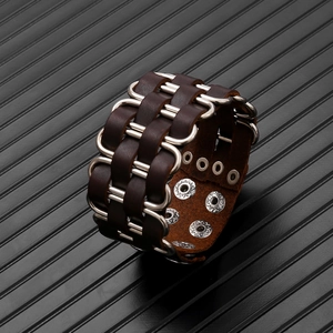 Close-up of wide brown leather punk bracelet with silver metal rings and snap buttons