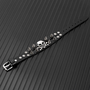 Close-up of punk leather bracelet with silver skull emblem and metallic cone studs