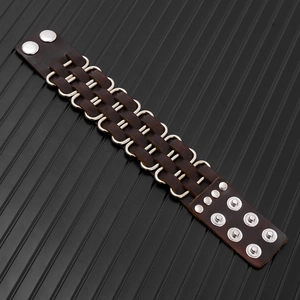 Detail view of brown punk leather bracelet with silver D-rings and metal snap buttons