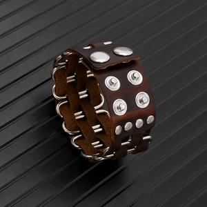 Detailed macro of brown leather cuff featuring silver rivets and metal ring connector