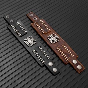 Detail of vintage punk leather bracelets with iron cross studs and woven stitching