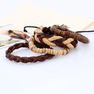 Dettaglio di bracciali multistrato in pelle con canapa intrecciata e perline di legno