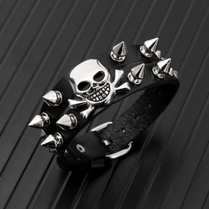 Detailed macro view of punk double black leather wristband with silver metal skull and spikes