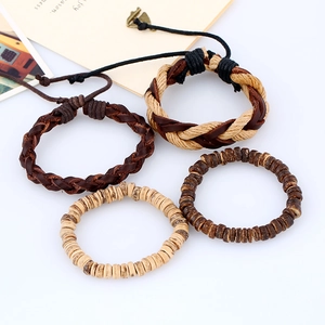 Set di quattro bracciali in pelle intrecciata retrò e perline di legno su sfondo bianco