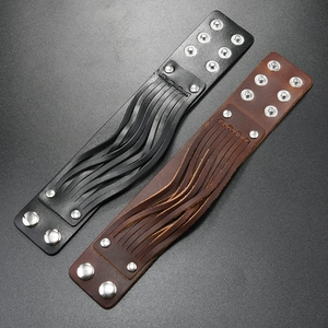 Detail view of adjustable wide leather punk bracelets in black and brown with silver rivets