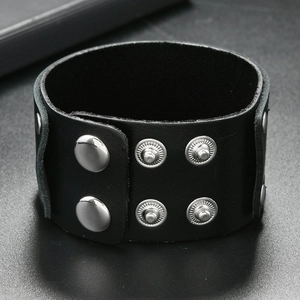 Close-up of black braided leather cuff featuring adjustable silver snap buttons on grey background
